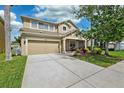 Lovely two-story home featuring a green lawn, an attached garage and a landscaped garden bed at 2800 Flagler Ct, Trinity, FL 34655
