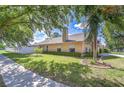 Well-manicured side yard with lush green lawn, mature trees, and a white privacy fence at 2927 Hickory Grove Dr, Valrico, FL 33596