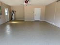 Spacious garage with painted floor, overhead lighting, and neutral paint at 3355 Abeline Rd, Spring Hill, FL 34608