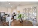 Open dining area with wood table, gallery wall, and modern lighting adjacent to a kitchen with stainless appliances at 37111 Sagemoor Dr, Zephyrhills, FL 33541