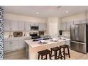 Well-equipped kitchen with gray cabinetry, stainless steel appliances, and a center island with seating at 37252 Sagemoor Dr, Zephyrhills, FL 33541