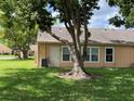 Exterior of home featuring a lush backyard with healthy green grass and shade provided by mature trees at 4814 Grist Mill Cir, New Port Richey, FL 34655