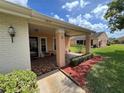 View of the exterior featuring a covered porch with patterned tile and a well-manicured lawn at 4814 Grist Mill Cir, New Port Richey, FL 34655