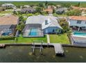 Backyard featuring a screened-in pool, boat lift, and dock for waterfront living at 5104 E Longboat Blvd, Tampa, FL 33615