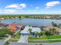 Waterfront home boasts lush landscaping, a white tile roof, and stunning views of the lake at 5104 E Longboat Blvd, Tampa, FL 33615