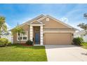 Inviting single-story home featuring a blue front door and well-manicured lawn at 632 Lake Cypress Cir, Oldsmar, FL 34677