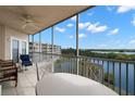Relaxing screened balcony has beautiful views of the lake and lush landscaping with chairs and table at 6475 Shoreline Dr # 5403, St Petersburg, FL 33708