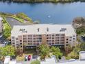 Aerial view shows the building's facade, balconies, landscaping, parking and serene lake views at 6475 Shoreline Dr # 5403, St Petersburg, FL 33708