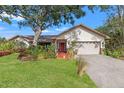 Charming single-story home with a well-manicured lawn, mature trees, and inviting front porch at 7201 15Th Ne Ct, St Petersburg, FL 33702