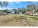 Large backyard with a shed, surrounded by a wooden fence, offering privacy and space at 827 Louise St, Brandon, FL 33511