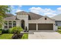 Charming home with well-manicured lawn and landscaping, showcasing a two-car garage and inviting architectural details at 1106 Tracey Ann Loop, Seffner, FL 33584