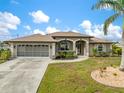 Charming single Gathering home featuring well manicured landscaping and a screened two car garage at 121 Colonial Sw St, Port Charlotte, FL 33952