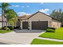 Inviting home exterior with a two-car garage, nice landscaping, and well-maintained lawn on a sunny day at 1430 Beaconsfield Dr, Wesley Chapel, FL 33543