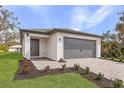Lovely single-story home boasting a well-manicured lawn, fresh landscaping, and a gray garage door at 1721 Shevlin St, North Port, FL 34286