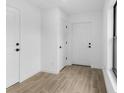Bright foyer featuring wood-look flooring, white walls, and ample closet space at 1721 Shevlin St, North Port, FL 34286