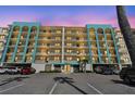 Condo with teal accents, black railings, multi-story, and parking spaces for residents and guests at 19531 Gulf Blvd # 210, Indian Shores, FL 33785