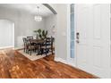 Dining area with hardwood floors, wainscotting, modern chandelier, and view into the front entrance at 20403 Walnut Grove Ln, Tampa, FL 33647