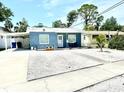 Charming single-story home with blue siding, a well-manicured yard, and a young palm tree at 3318 Boca Ciega N Dr, St Petersburg, FL 33710
