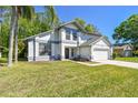 Inviting two-story home with a well-maintained lawn, two-car garage, and a welcoming entrance at 389 Waterford W Cir, Tarpon Springs, FL 34688