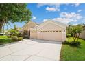 Charming home featuring a three car garage, manicured lawn and mature landscaping at 4608 Kilcoyne Ct, Lutz, FL 33558