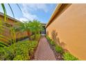 Brick walkway leading to the front entrance, surrounded by tropical landscaping and greenery at 4961 Marble Springs Cir, Wimauma, FL 33598