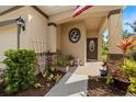 Inviting front porch showcasing decorative plants, an American flag, and a welcoming entrance, set in a beautifully landscaped area at 5826 Oak Mill Ter, Palmetto, FL 34221