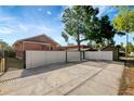 Spacious backyard with concrete driveway, white fence, and secure gated entry at 6414 N Central Ave, Tampa, FL 33604