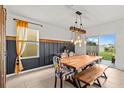 Bright dining room with wooden table, bench, and chairs near sliding glass door at 10937 Penny Gale Loop, San Antonio, FL 33576