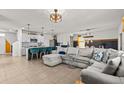 Open-concept kitchen and living room with island, barstools, and comfortable sectional couch at 10937 Penny Gale Loop, San Antonio, FL 33576