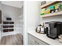 Walk-in pantry with white wire shelving, a coffee station with beverage shelving, and wood grain flooring at 12164 Cattleside Dr, Riverview, FL 33579