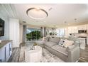 Inviting living room featuring a plush gray sofa, modern light fixture, open floor plan, and access to outdoor patio at 12166 Cattleside Dr, Riverview, FL 33579