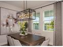 Dining room featuring a modern chandelier, large windows with outdoor views, and seating for six at 12168 Cattleside Dr, Riverview, FL 33579