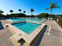 Community pool and spa area surrounded by palm trees with plenty of space for residents to lounge and soak up the sun at 1423 Pine Glen Ln # D2, Tarpon Springs, FL 34688