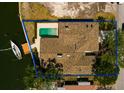 Aerial view of waterfront property with private dock, boat and a pool with a blue outline of the property at 2063 Illinois Ne Ave, St Petersburg, FL 33703