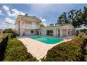 Beautiful backyard featuring a sparkling pool, lush landscaping, and a charming spiral staircase to the second floor at 2063 Illinois Ne Ave, St Petersburg, FL 33703