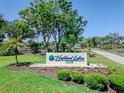 Community entrance sign to Highland Lakes Club, surrounded by mature trees and manicured landscaping at 2241 Shelly Dr # D, Palm Harbor, FL 34684