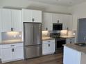 Modern kitchen with white cabinets, stainless steel appliances, subway tile backsplash, and granite countertops at 232 Columbia Dr, Tampa, FL 33606
