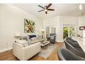 Comfortable living room featuring hardwood floors, a ceiling fan, and sliding glass doors to the patio at 232 Columbia Dr, Tampa, FL 33606