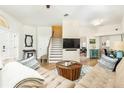 Bright living room with wood floors, white brick accent wall, and staircase leading to the upper level at 232 Columbia Dr, Tampa, FL 33606