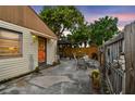 Cozy back patio, perfect for outdoor dining, with a fenced yard and mature trees providing shade at 251 72Nd Ave, St Pete Beach, FL 33706