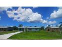 A single story home with green lawn, blue sky and wispy clouds at 2801 Poinciana Ct, Punta Gorda, FL 33950