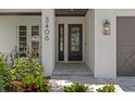 Elegant entryway featuring a modern door, stylish lighting, and lush landscaping at 3406 W Alline Ave, Tampa, FL 33611