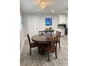 Dining area with new hardwood flooring, modern light fixture, and adjacent kitchen with white cabinets at 428 45Th N Ave, St Petersburg, FL 33703