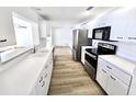 Bright and modern kitchen featuring white cabinets, countertops, and stainless steel appliances at 502 Palm Dr, Largo, FL 33770