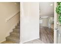 Bright foyer with wood-look floors, leads to an open-concept living space and staircase, with a glimpse of the kitchen at 5022 Chipotle Ln, Wesley Chapel, FL 33544