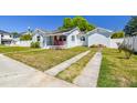Charming light blue home with a well-manicured lawn and a welcoming front porch with red Adirondack chairs at 503 N Macdill Ave, Tampa, FL 33609
