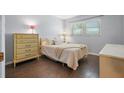 Cozy bedroom with wood floors, a full bed, a large window, and dresser at 5246 81 N St # 24, St Petersburg, FL 33709