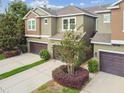 Aerial view of a townhome with a driveway and lush landscaping at 5619 Tranquil Pond Pl, Riverview, FL 33578