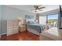 Cozy bedroom with a ceiling fan, wood floors, and a bright window with water views at 6277 Bahia Del Mar Blvd # 110, St Petersburg, FL 33715
