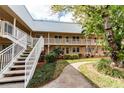 Well-maintained condo building with two stories, white stairs and balcony railings, surrounded by lush landscaping and walking paths at 10035 63Rd N Ave # 23, St Petersburg, FL 33708